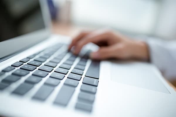 HFotogradía de una persona escribiendo con un teclado